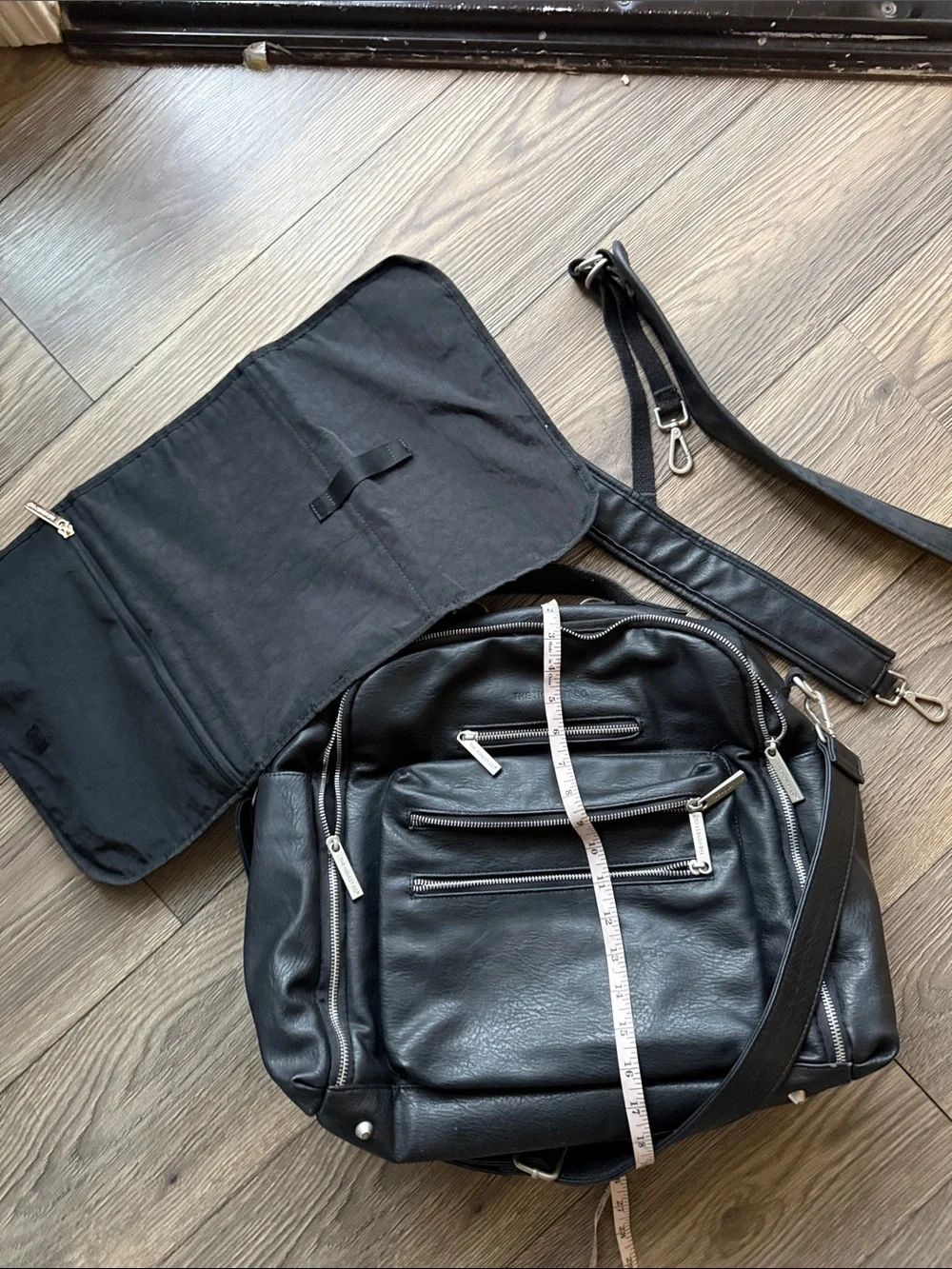 The Honest Company Black Vegan Leather Diaper Bag backpack model cross country